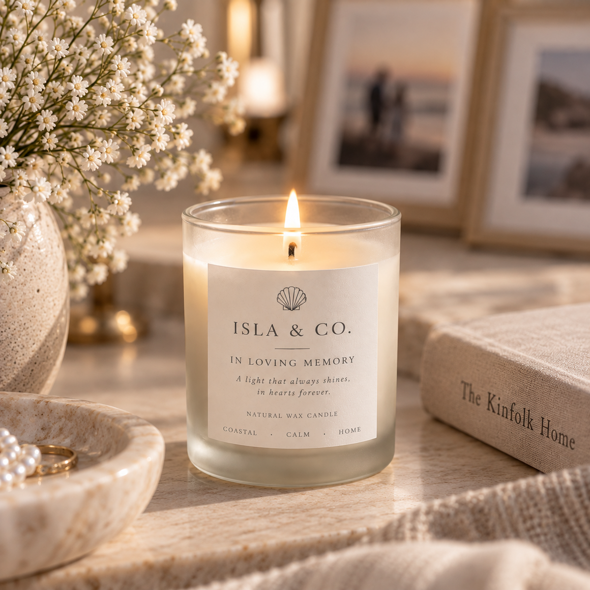In Loving Memory candle styled with softly blurred photo frames and flowers