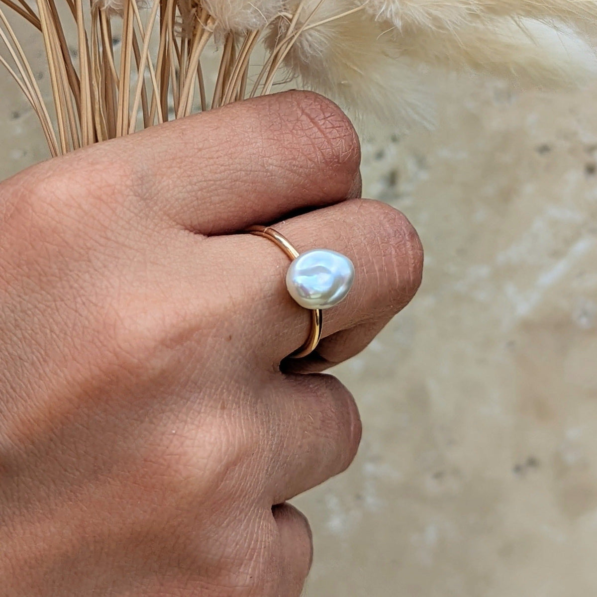 Gold baroque pearl ring worn on the hand