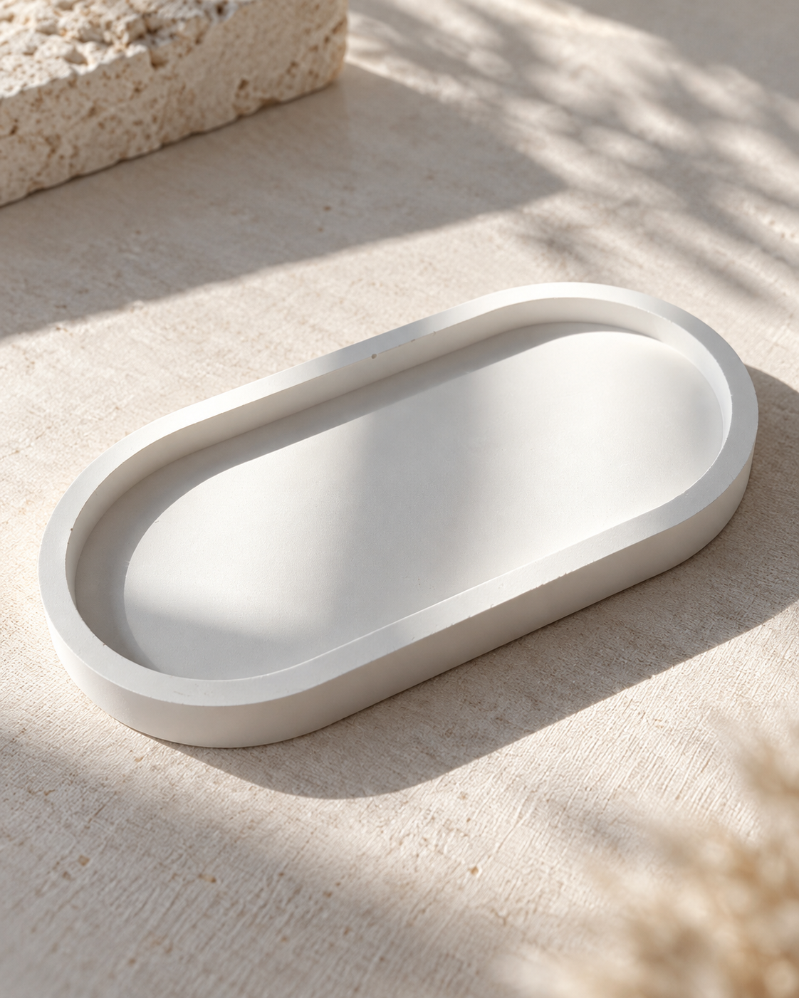 White stone oval tray styled on a neutral textured surface
