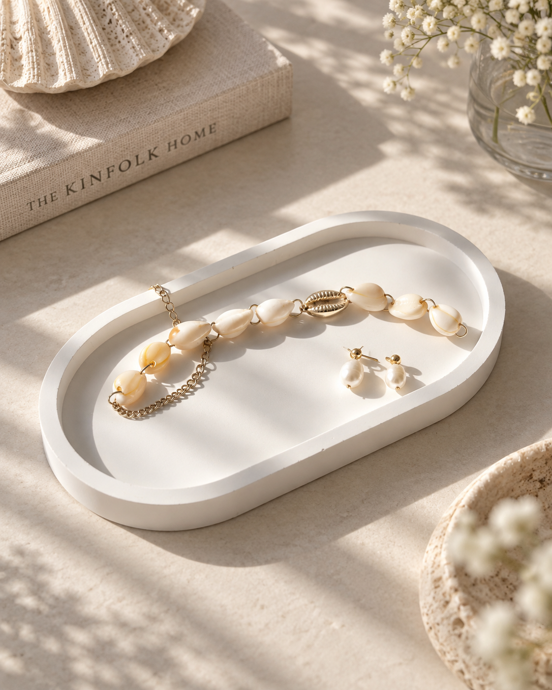 Stone oval tray styled with shell and pearl jewellery