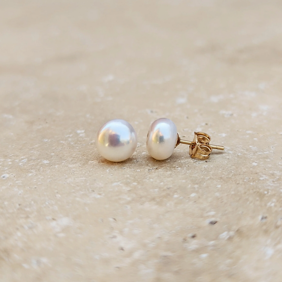 Eloise pearl stud drop earrings on a neutral stone background