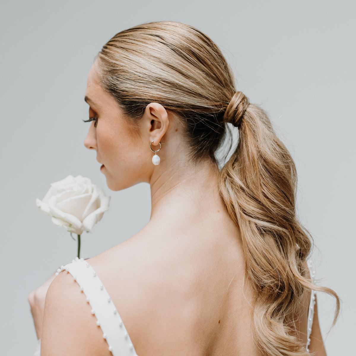 Bride wearing Sia baroque pearl hoop earrings
