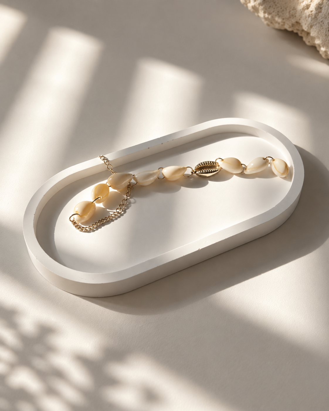 Stone oval tray styled with shell jewellery